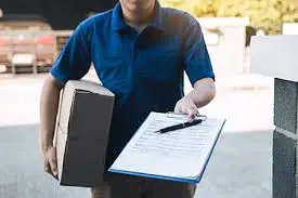 Person loading groceries and packages into a car for delivery